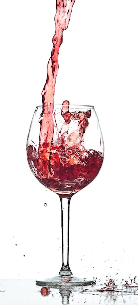 Red wine splash over white background at studio