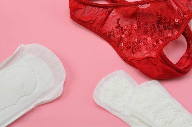 Photo red women39s panties and pads on a pink background