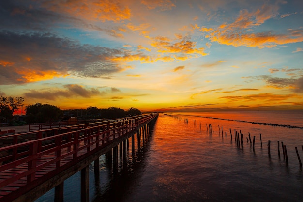 Red wooden bridge and sea in the morning,In the morning the red bridge and the sun rise on the horiz