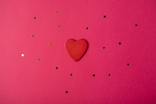 Red wooden heart and little stars. Valentine's day concept. Flat lay, top view.