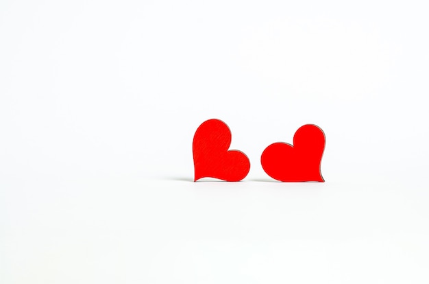 Photo red wooden hearts side by side look at each other