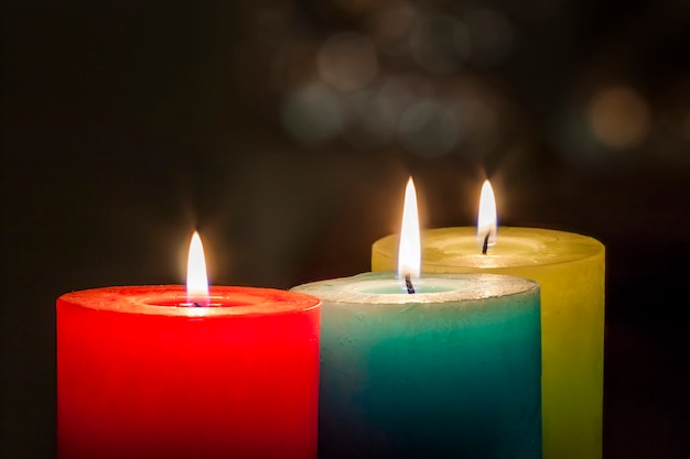 Red, yellow and green candles with blurred bokeh