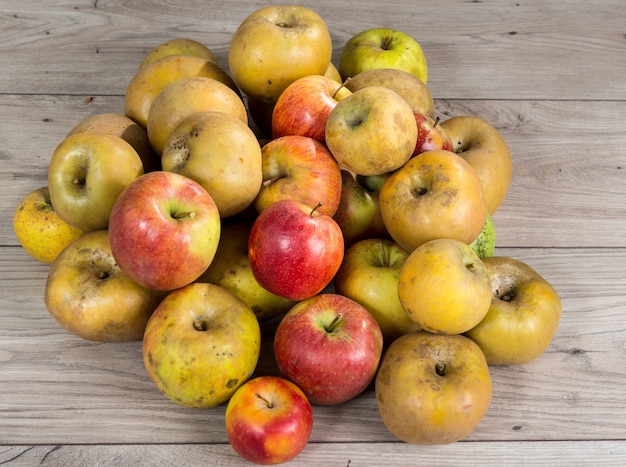 Red and yellow organic apples on wooden table