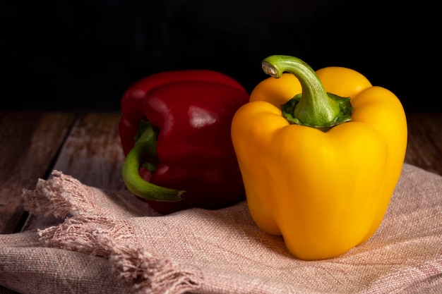 Red and yellow peppers lie on the table in the kitchen