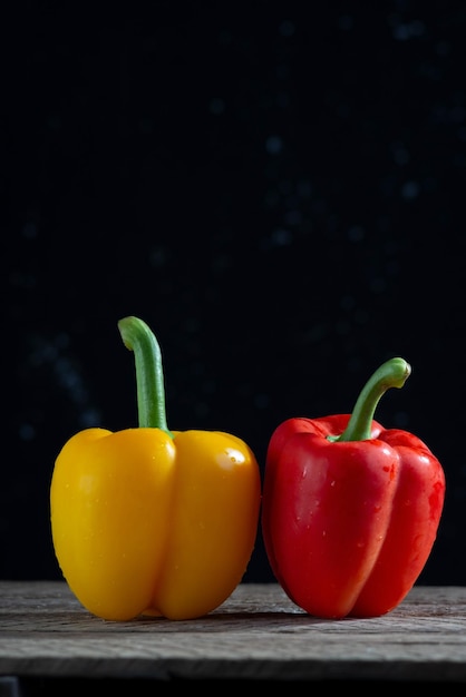 Red and yellow peppers for salad on a wooden table in a rustic style minimalistic concept