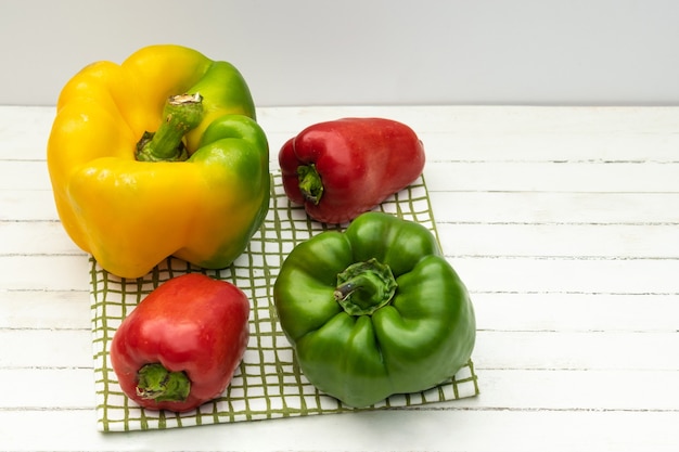 Red yellowgreen ripe bell peppers on wooden background selective focus