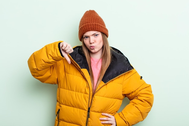 Redhair woman feeling crossshowing thumbs down winter concept