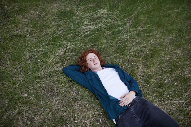 Photo redhaired man relaxing on grass serene in nature