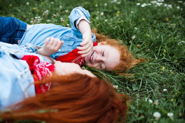 Redhaired mother and daughter have fun in nature