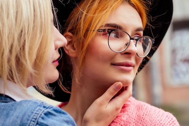 Redhaired young ginger woman feeling love to her blonde girlfriend in Europe streets