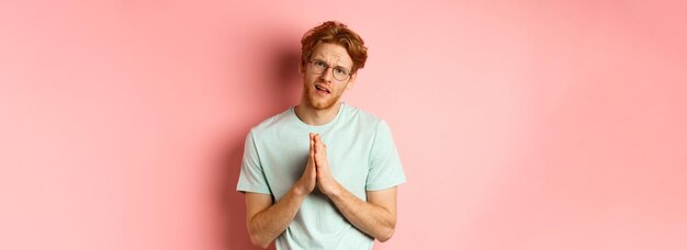 Photo redhead bearded guy begging for favour holding hands in namaste gesture and asking for help need             person