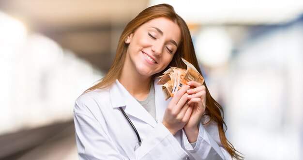 Redhead doctor woman holding money