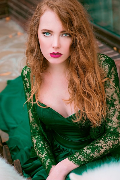 redhead (ginger) beautiful young girl in long green dress