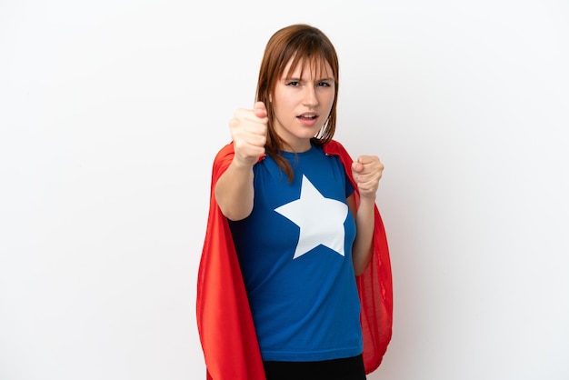 Redhead girl isolated on white background in superhero costume and fighting