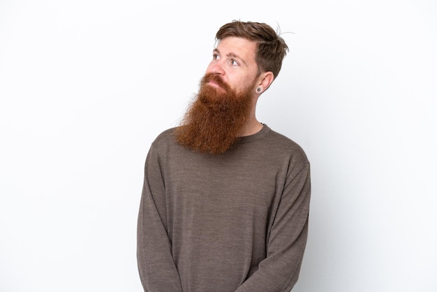 Redhead man with beard isolated on white background looking to the side