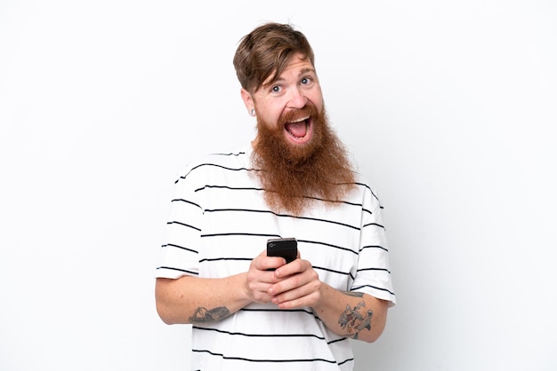 Redhead man with beard isolated on white background surprised and sending a message