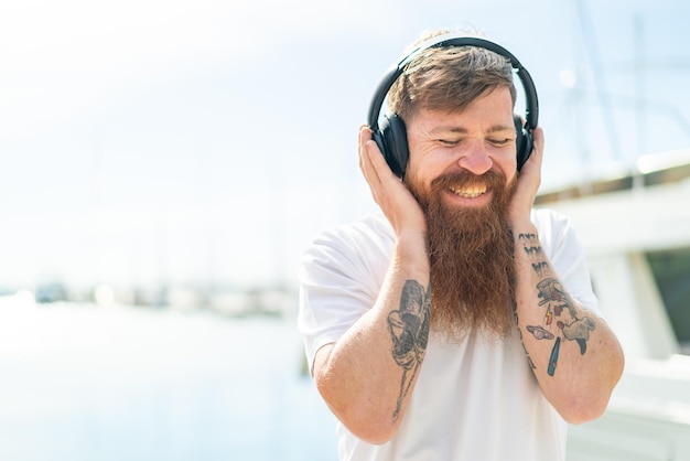 Redhead man with beard listening music