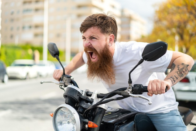 Redhead man with beard with a motorcycle