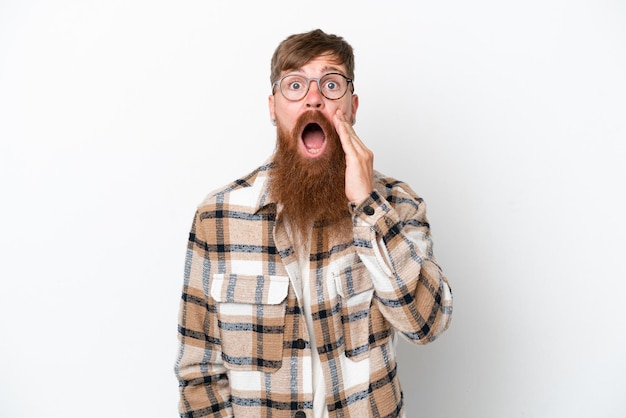 Redhead man with long beard isolated on white background with surprise and shocked facial expression