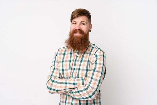 Redhead man with long beard over white wall with arms crossed and looking forward