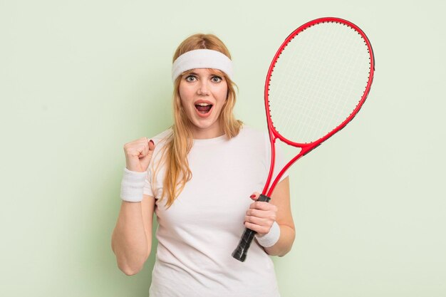 Redhead pretty woman shouting aggressively with an angry expression tennis concept