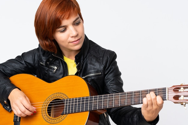 Redhead woman playing guitar