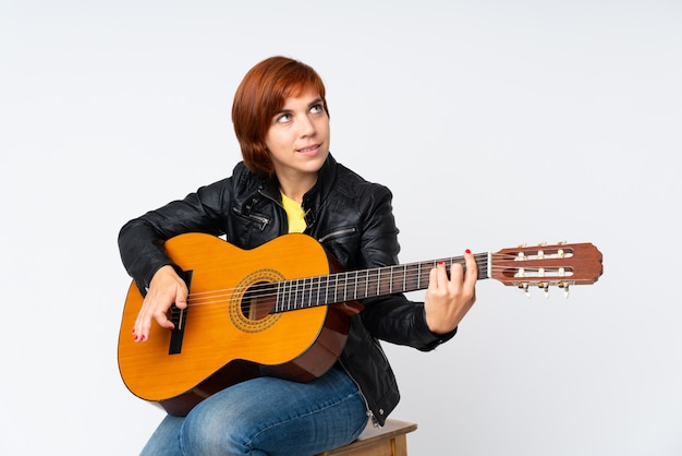 Redhead woman playing guitar