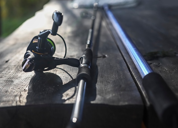 Reel of fishing rod and net handle in perspective close up fishermans equipment