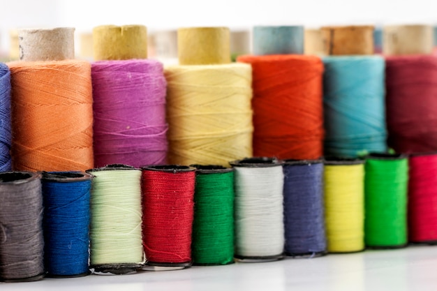 Reels or spools of multicolored sewing threads.