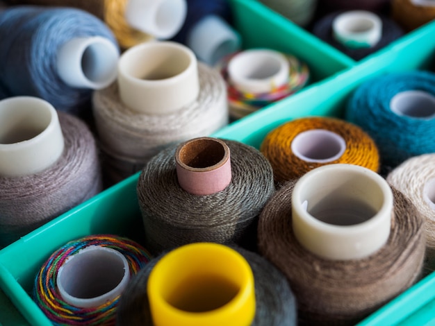 Reels with threads of different colors for sewing. Threads located in the box. The view from the top on threads for sewing.