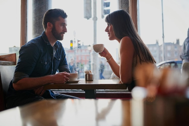 Reenacting their first date Cropped shot of an affectionate young couple sitting in a coffee shop while on a date