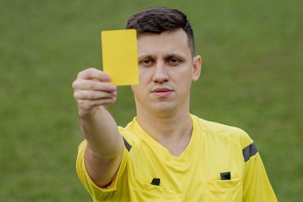 Referee showing a red card to a displeased football or soccer player while gaming. Concept of sport, rules violation, controversial issues, obstacles overcoming.