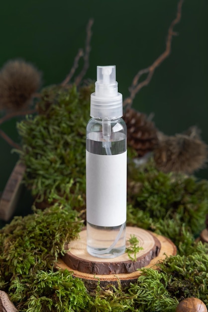 Refillable Cosmetic spray Dispenser on wooden piece near green moss closeup Label mockup