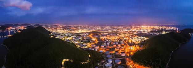 Refinery oil industry zone at night time over colourful and lighting with blue sky aerial 