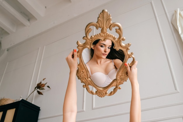 Photo reflection of beautiful girl portrait holding mirror