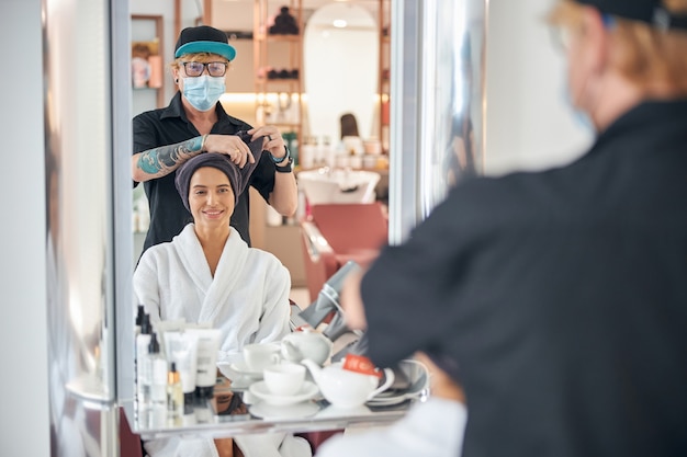 Reflection in the salon mirror of the client and hairdresser