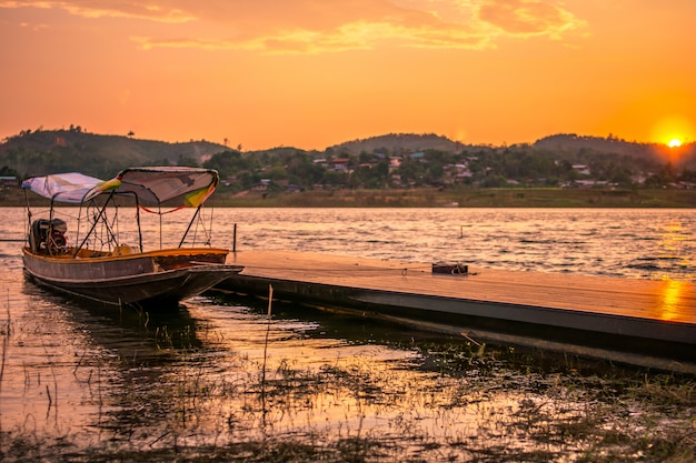 Reflection of Single Boat with Burning Sky During Sunrise/Sunset