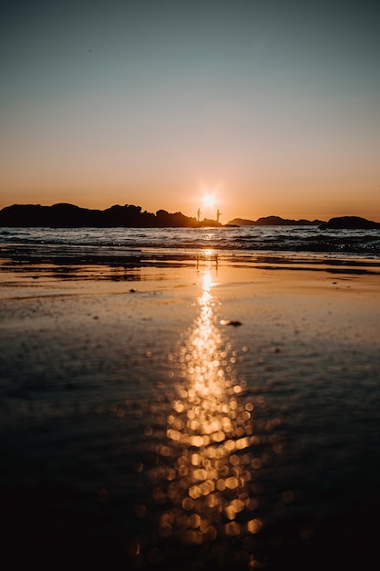 Reflection of the sunset on the sand on the beach