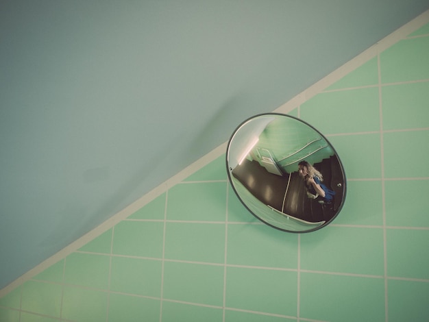 Photo reflection of woman standing on staircase in mirror