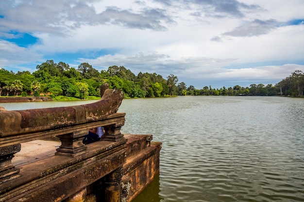 Reflections of the jungle over the broad moat of the ancient temple of Angkor Wat in Cambodia