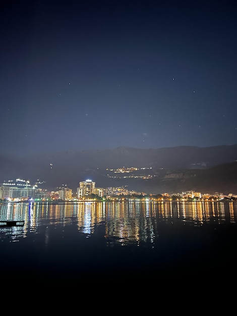 Reflections in the sea of illumination of the night town at the foot of the mountains