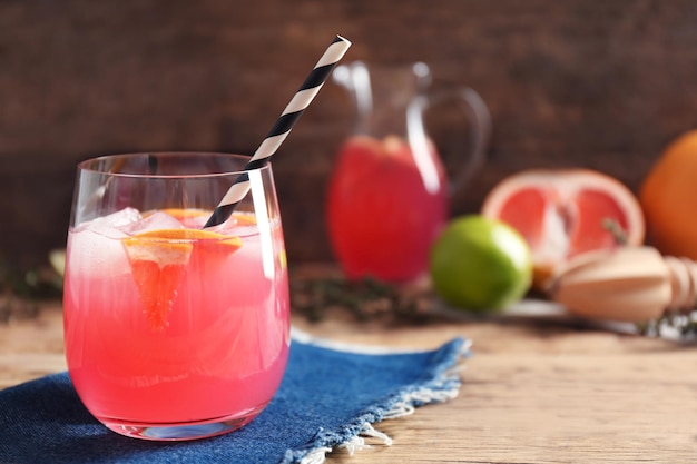 Refreshing cocktail with grapefruit on wooden table