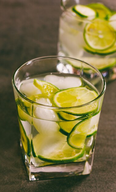 A refreshing cocktail with green lemon and ice