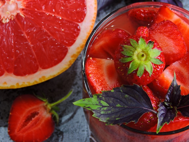 Refreshing detox drink for weight loss with strawberries, grapefruit and blue basil.