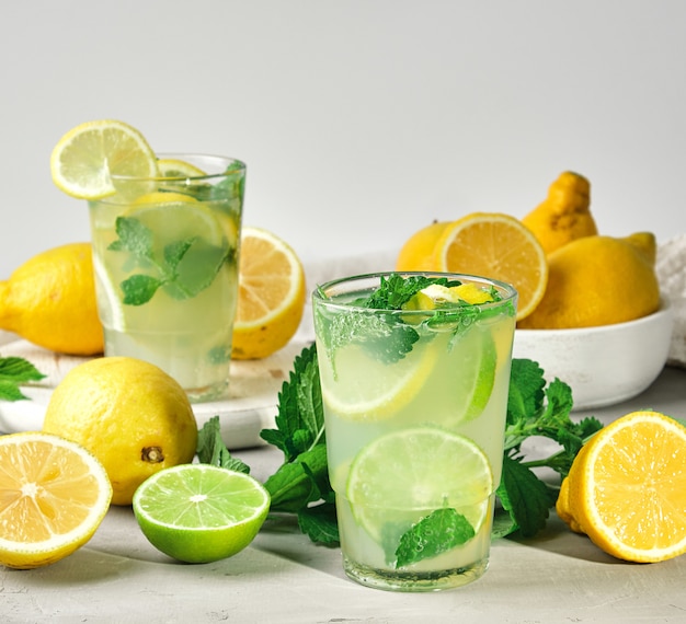 Refreshing drink lemonade with lemons, mint leaves, lime in a glass