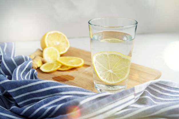 Refreshing drink with lemon. Warm water with a slice of lemon next to a blue napkin