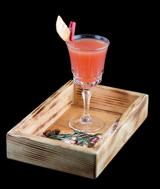 Refreshing grapefruit cocktail in a glass on a wooden Board Dark background