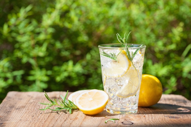 Refreshing lemonade drink with rosemary in glass