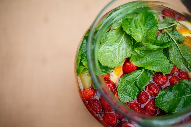 Refreshing lemonade with fresh fruit orange lemon cherry and mint leaves. Delicious non-alcoholic fruit cocktail in a jug