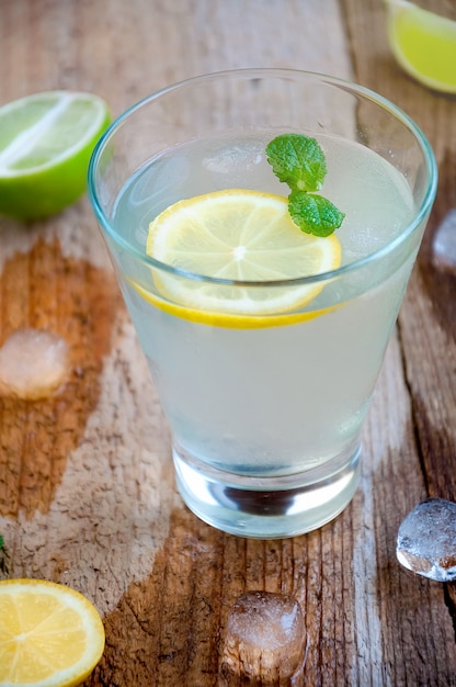 Refreshing Summer Cocktail with Citrus Fruit Ice and Mint on Wooden Table